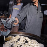 A jalebi-making vendor near Choubarji Chowk attracts customers by frying jalebis, used as a dessert in Iftar during the holy month of Ramadan
