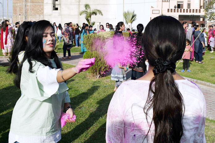 Hindu community girls celebrate the Holi festival, a vibrant Hindu Spring Festival of Colors at Mother Village Park