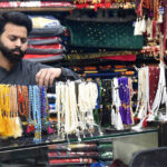 A shopkeeper is arranging rosaries (tasbih) made of beads and rare stones which are widely used by worshippers during the blessed month of Ramadan to attract customers in an Urdu Bazaar