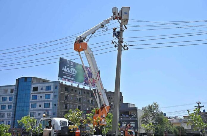 IESCO workers busy installed new electric wires on electric pole at IJP Road