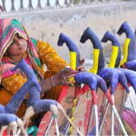 Gypsy woman preparing hand-made paper decoration stuff (Ghughu Ghoray) at roadside to earn livelihood