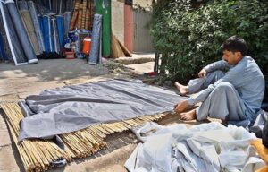 Workers install aspen pads in air coolers as temperatures soar in the capital