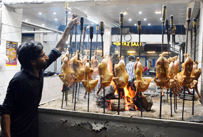 A worker busy in preparing the sajji for the customers at local restaurant