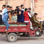 Children ride on a loader rickshaw to for outing on the second day of Eid al-Fitr celebrations in the city