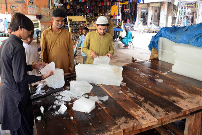 People purchasing the ice pieces from vendor at bacha khan chowk