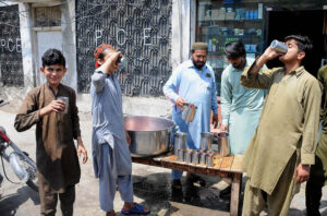 A Volunteer distributing free drinks among the people during hot weather in the city.