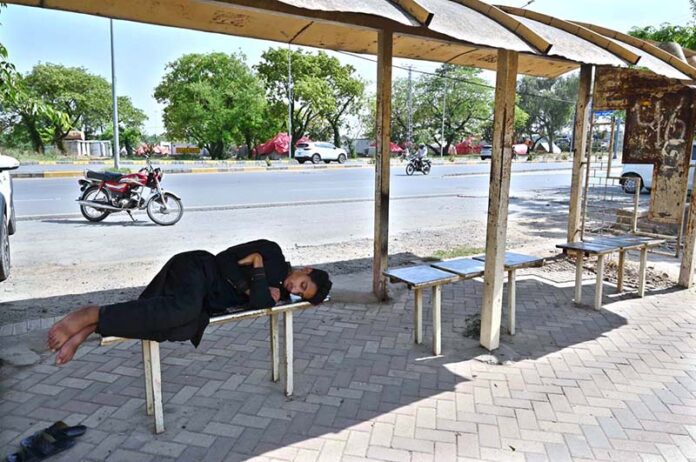 A person taking nap on bench at Aabpara Bus Stop in the Federal Capital