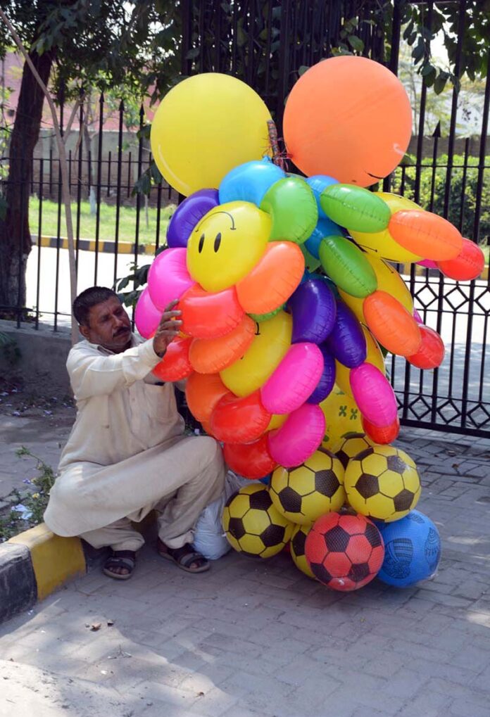 A street vendor displaying air filled toys to attract the customers