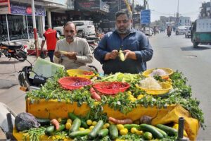 A street vendor sells fresh salads made from various vegetables to attract customers near Dera Adda Chowk.