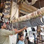 A vendor displays sickles (used for harvesting wheat) to attract customers at his shop