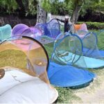 A vendor is busy arranging and displaying mosquito nets to attract the customers along Lehtrar Road