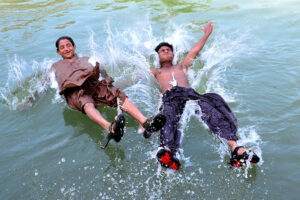 A youngster dives in the water canal during hot weather in the city