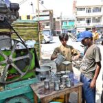 A vendor selling sugarcane juice at his roadside setup during hot weather in the city