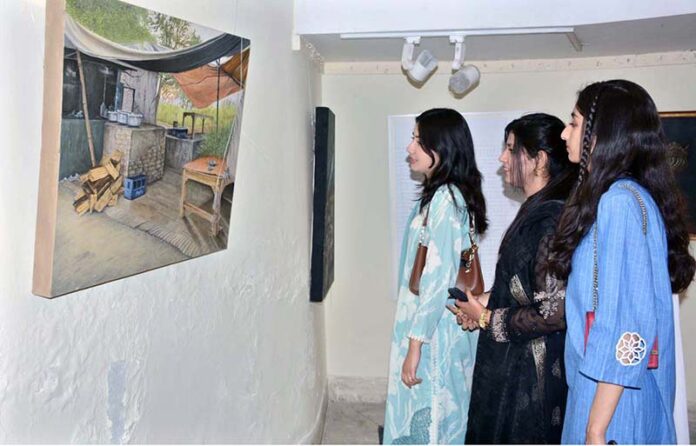 Students take keen interest in a painting while visiting the Lyallpur Art Festival at Faisalabad Arts Council