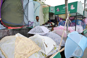 A vendor is selling umbrellas at his road side setup for livelihood