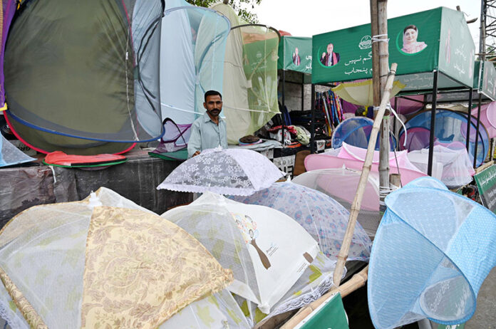 A vendor is selling umbrellas at his road side setup for livelihood