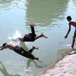 Youngsters jumping and bathing in the Chenal Mori Canal to get some relief from hot weather in the city