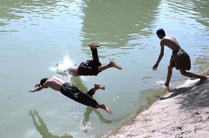 Youngsters jumping and bathing in the Chenal Mori Canal to get some relief from hot weather in the city