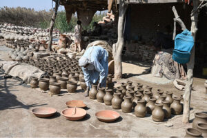 A worker arranging clay-made stuff for drying purpose at his work place in kumharpara.