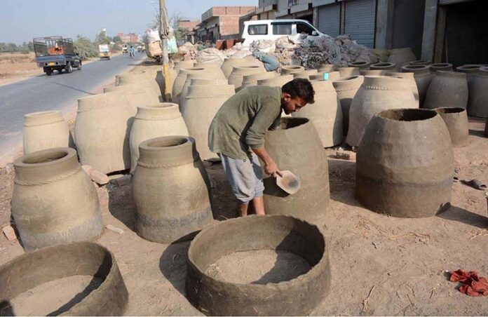 Labourer busy in preparing traditional clay oven (tandoor) at his workplace as the world marks International Labour Day. May 1st, International Workers’ Day, commemorates the historic struggle of working people throughout the world. In 1884, the Federation of Organized Trades and Labour Unions passed a resolution stating that eight hours would constitute a legal day’s work from and after May 1, 1886