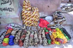 A gypsy woman sits along Sadar Road, waiting for customers to sell bangles.