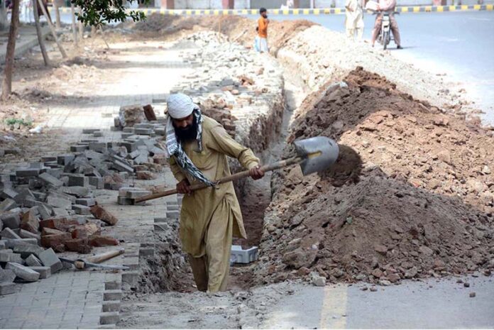 A daily wage labourer engaged in excavation work for laying a new pipeline near Iqbal Stadium