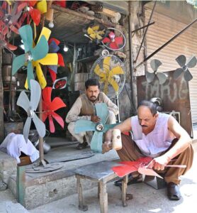 A mechanic is making room cooler fans at workplace in the city