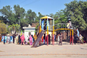 Families with their children enjoy the swings at Qasim Bagh Park