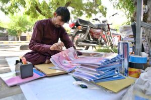 Worker busy in book binding at his workplace near Sitara Market in the Federal Capital