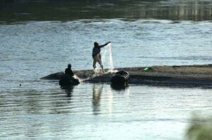 Villagers busy in catching fish with the help of fishing net at Charsadda River.