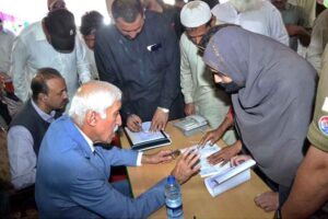 Federal Minister for Investment Board Qaiser Ahmad Sheikh listens to a woman’s complaint during an open court at his dera to address public grievances and resolve issues on the spot