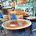 A vendor busy frying chicken to attract customers at his setup near Six Road Area in the City