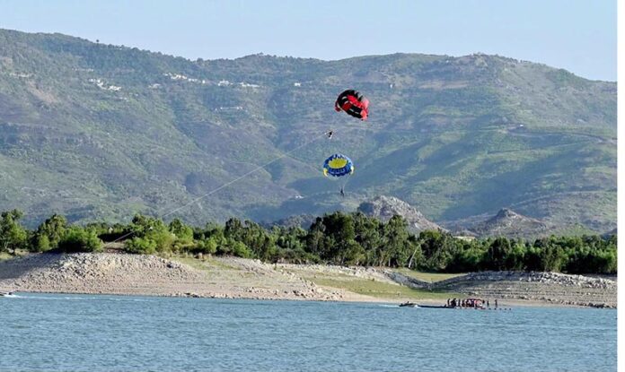 Tourists enjoy parasailing with the help of a water jet bike at Khanpur Dam, located about 50 km from Islamabad in Khyber Pakhtunkhwa