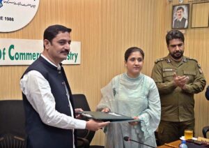President Chamber of Commerce Sargodha Khawaja Yasir Qayyum and Principal Police Public High School Qurat-ul-Ain exchanging documents during MoU signing ceremony between Chamber of Commerce and Police Public High School DPO.