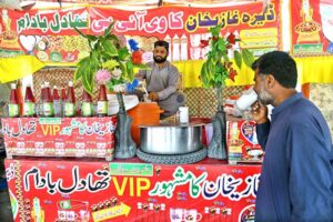 A vendor prepares a traditional summer drink (thadal) to quench the thirst of the streets of Larkana at roadside setup near Faridabad.