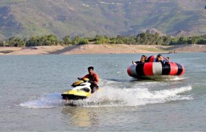 Tourists enjoy parasailing with the help of a water jet bike at Khanpur Dam, located about 50 km from Islamabad in Khyber Pakhtunkhwa