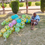 An aged man displays baloons at Chenab Park for livelihood