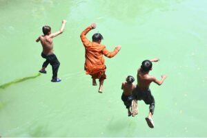 Youngsters jumping and bathing in the water canal to get some relief from hot weather in the city.