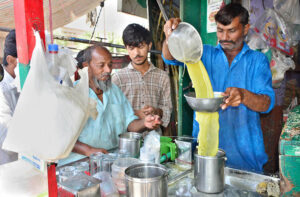 A street vendor prepares fresh sugarcane juice to attract customers and help them beat the heat amid the city’s hot weather