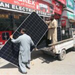 A vendor busy offloading solar panels from a delivery van in the Kala Bari area in the city