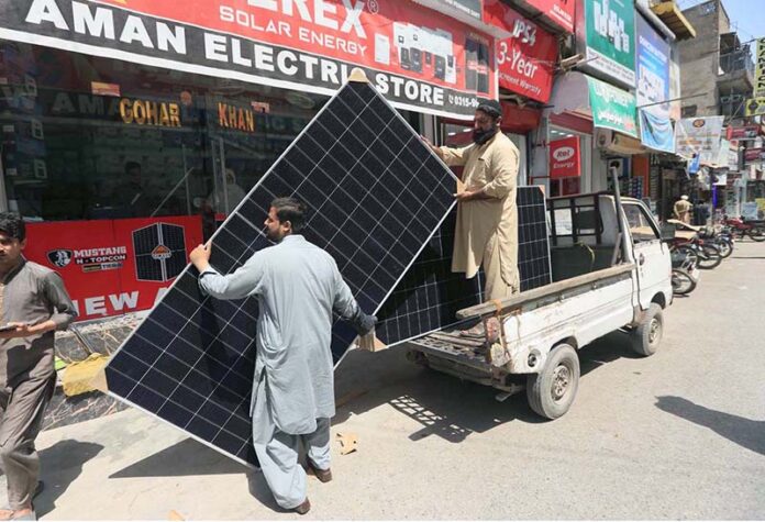 A vendor busy offloading solar panels from a delivery van in the Kala Bari area in the city