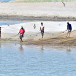 Fishermen cast their net to catch fish into the Indus River near Hussainabad