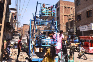 Children enjoying traditional swings of a vendor in the street on the 2nd day of Eid-ul-Fitr celebrations in the city
