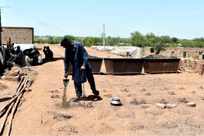 A laborer is engrossed in his routine work at a brick kiln, striving hard to earn a livelihood
