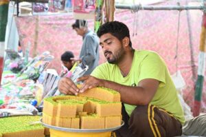 A vendor is arranging and selling traditional Sweet to attract customers.