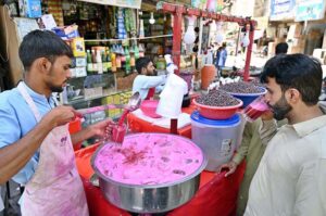A street vendor sells chilled falsa drinks to quench the thirst of passersby under the blazing sun at Pakistan Chowk