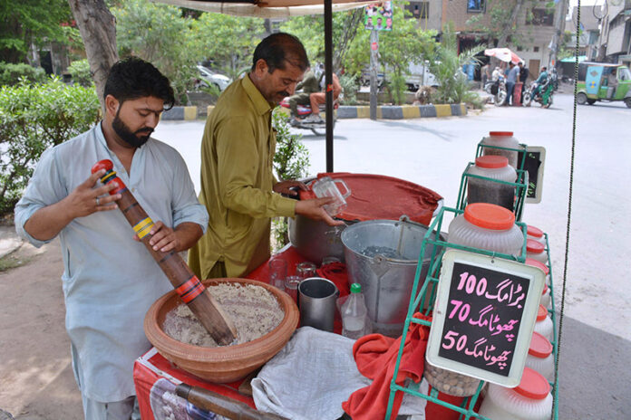 A vendor skillfully prepares refreshing drink Sardai to quench summer thirst in the city