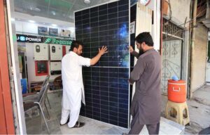 A vendor busy offloading solar panels from a delivery van in the Kala Bari area in the city