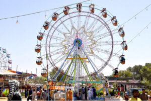 Children enjoying traditional swings of a vendor in the street on the 2nd day of Eid-ul-Fitr celebrations in the city