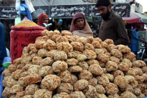 A vendor selling the traditional food item Jaggery (Gurr) to the customers outside the Dehli gate in the Provincial Capital